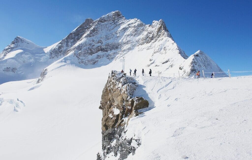 Panoramic view of the Aletsch Glacier under a clear blue sky, highlighting its vast expanse and the surrounding Alpine peaks.