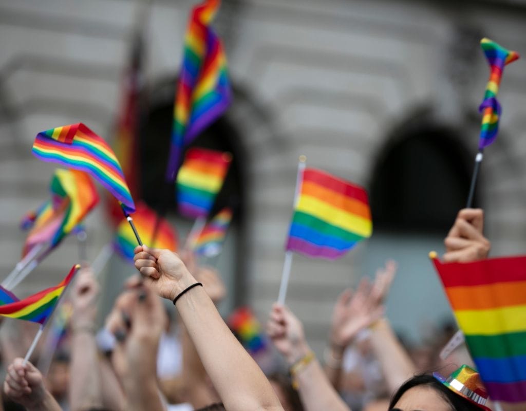 LGBTQ flags waving proudly against the backdrop of Berlin's cityscape, symbolizing the city's open and inclusive spirit.