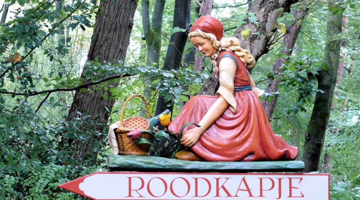 Wooden figure of Little Red Riding Hood in the forest at Efteling Theme Park