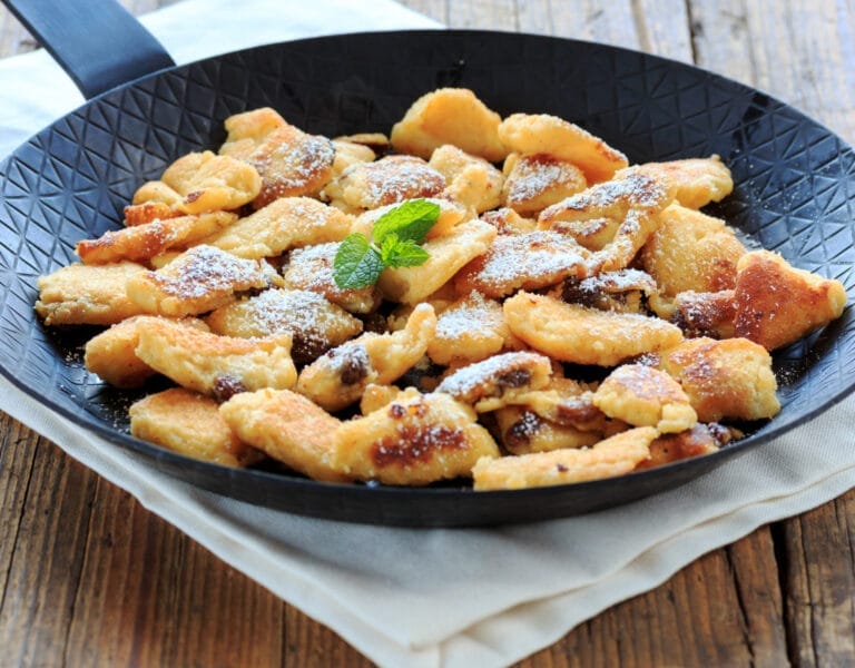 Traditional Austrian Kaiserschmarrn with powdered sugar and fruit compote