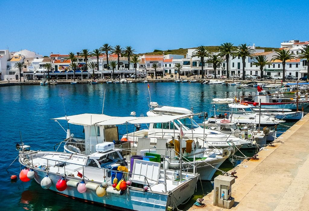 Bay in Menorca with small boats and houses in the background