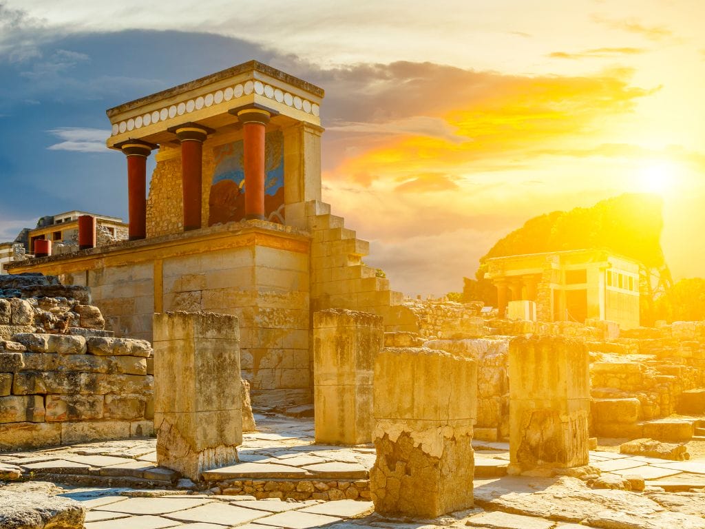 Palace of Knossos illuminated by the evening sun, showcasing ancient ruins and vibrant colors.
