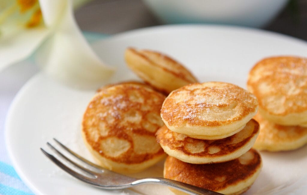 Traditional Dutch poffertjes with powdered sugar and butter