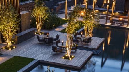 Exterior view of The Chedi Andermatt hotel with snow-covered mountains in the background, highlighting its luxurious architecture and alpine setting.