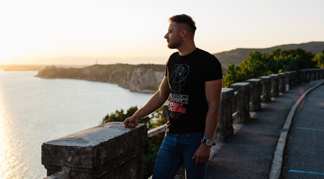 Relaxed Italian man looking into the distance while standing on a bridge